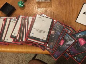 Old sleeved trading cards on the table with newly printed monster cards for Memaws Monsters Tower Defense prototype by Calvin Keene